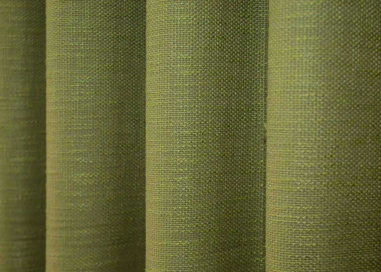 Warm matte green linen curtains with a coarse weave, providing privacy while allowing soft, diffused natural light.