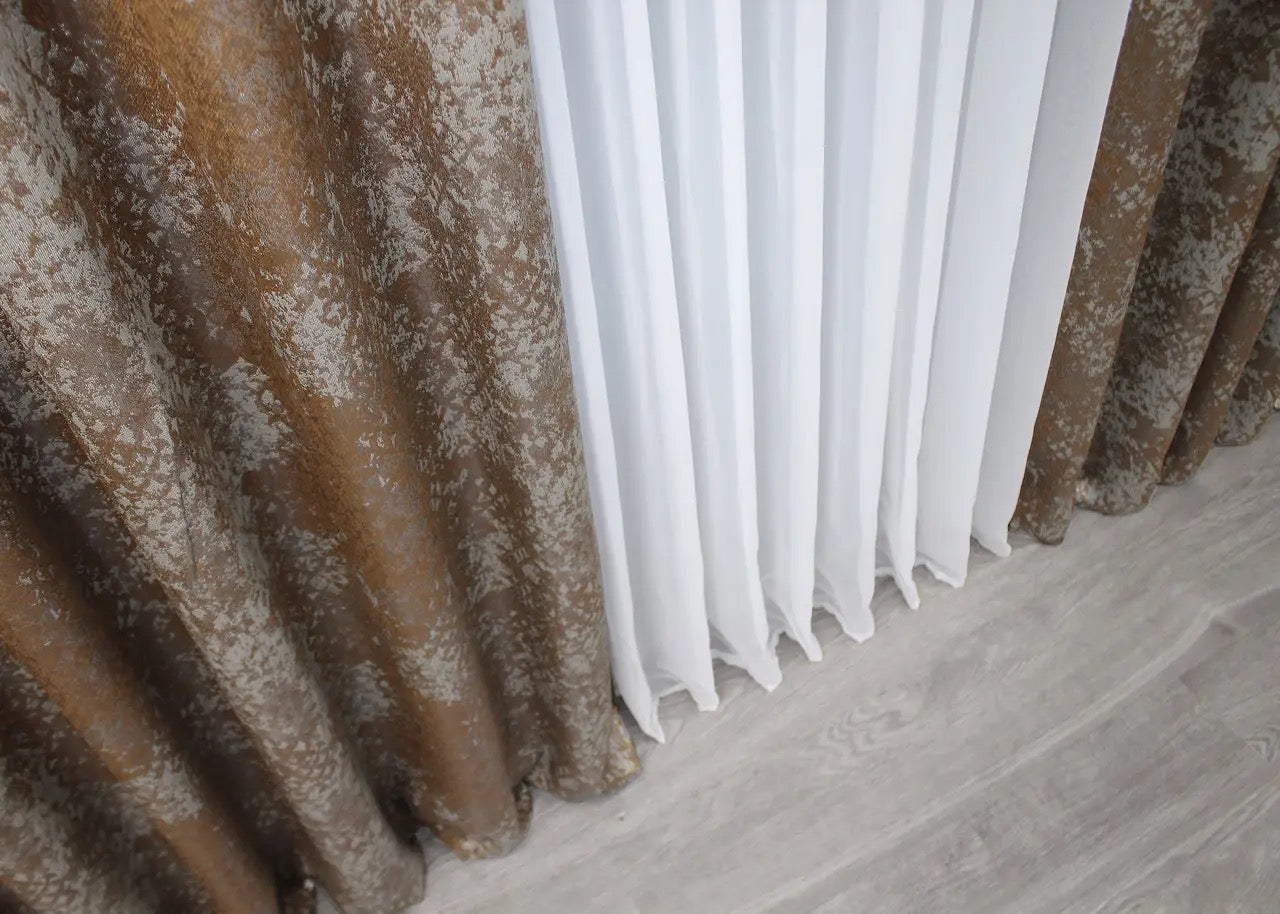 Stylish copper and grey linen curtains with a graceful drape, perfect for creating a cosy yet refined atmosphere.