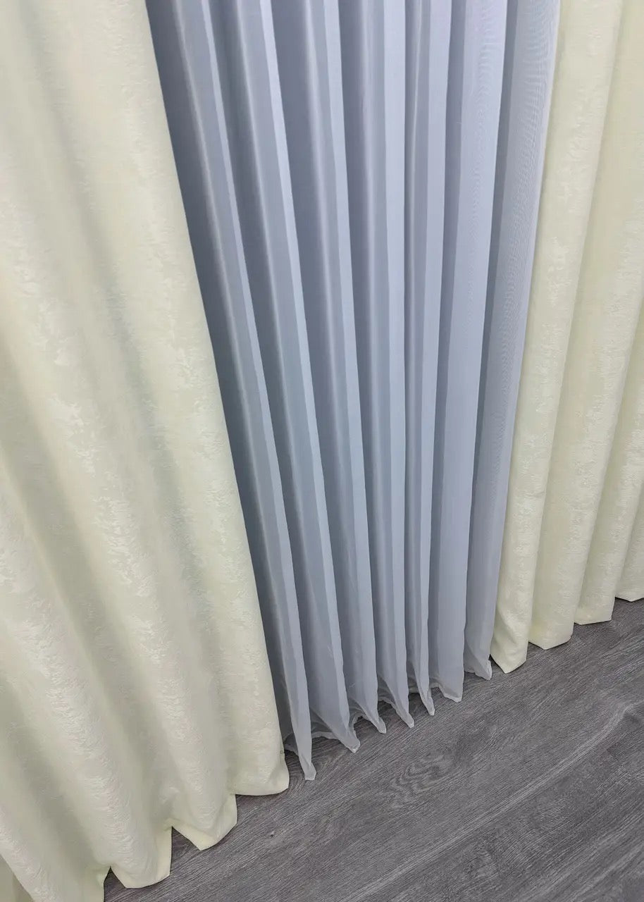 Close-up of cream jacquard curtains showcasing the luxurious texture and detailed woven patterns.