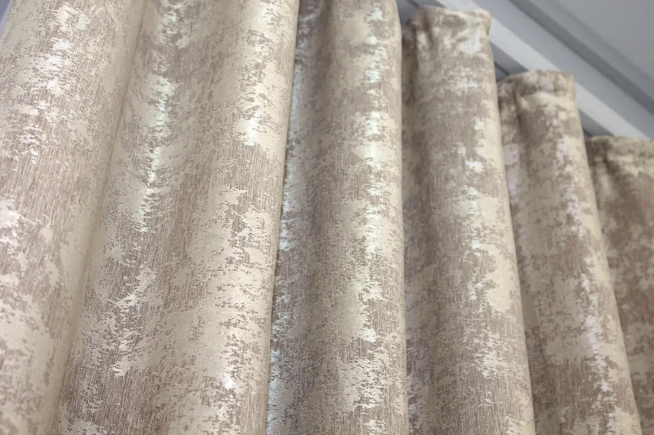 Soft grey-beige jacquard curtains with a textured woven pattern, creating a luxurious yet warm and inviting atmosphere.