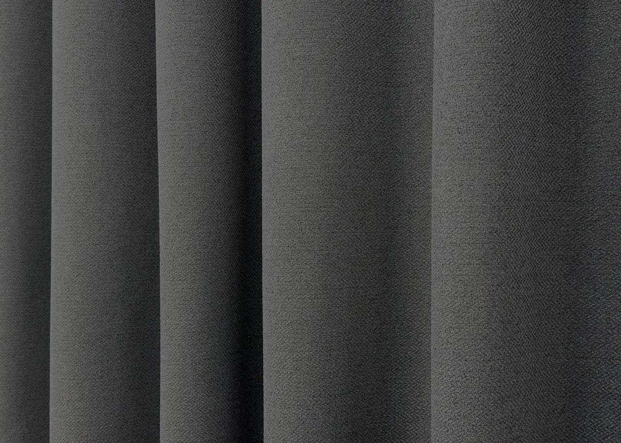 Stylish blackout curtains in graphite with a natural linen weave, blocking external light for a restful atmosphere.
