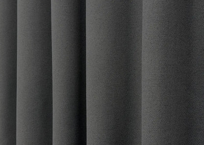 Stylish blackout curtains in graphite with a natural linen weave, blocking external light for a restful atmosphere.
