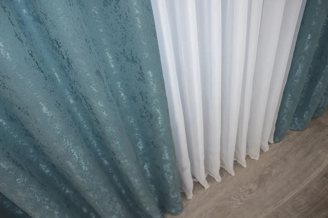 Soft azure linen curtains featuring a refined marble pattern for a sophisticated home look.
