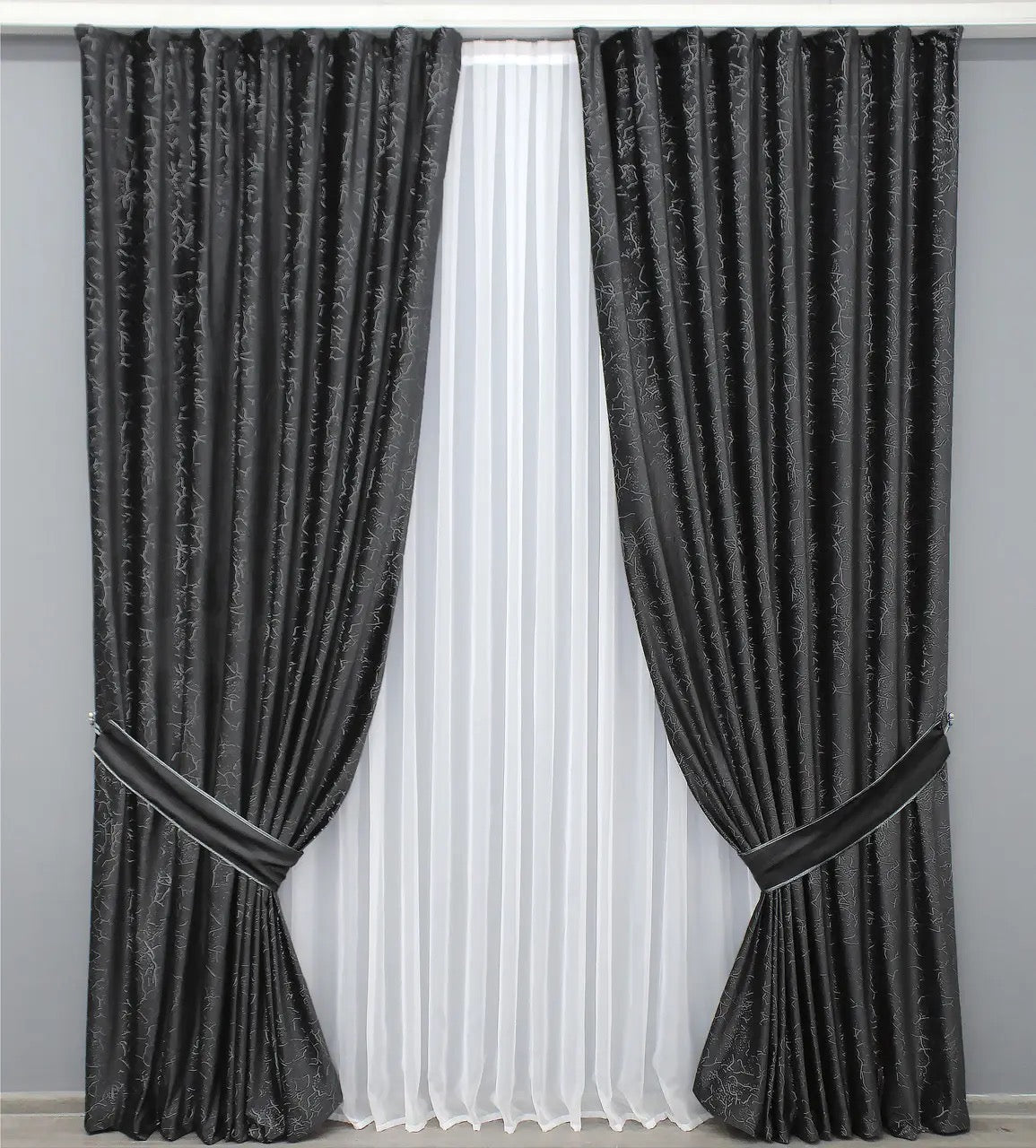 Premium charcoal black velvet drapes with a sophisticated pattern, offering high-quality blackout and room darkening effects for home interiors.
