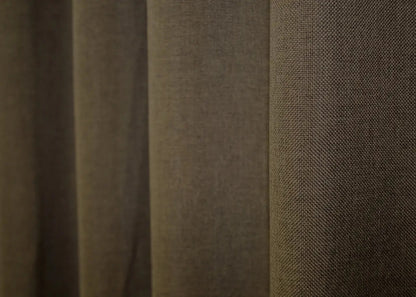 Earthy brown coarse-woven linen curtains, designed for light filtering and creating a cosy ambiance.
