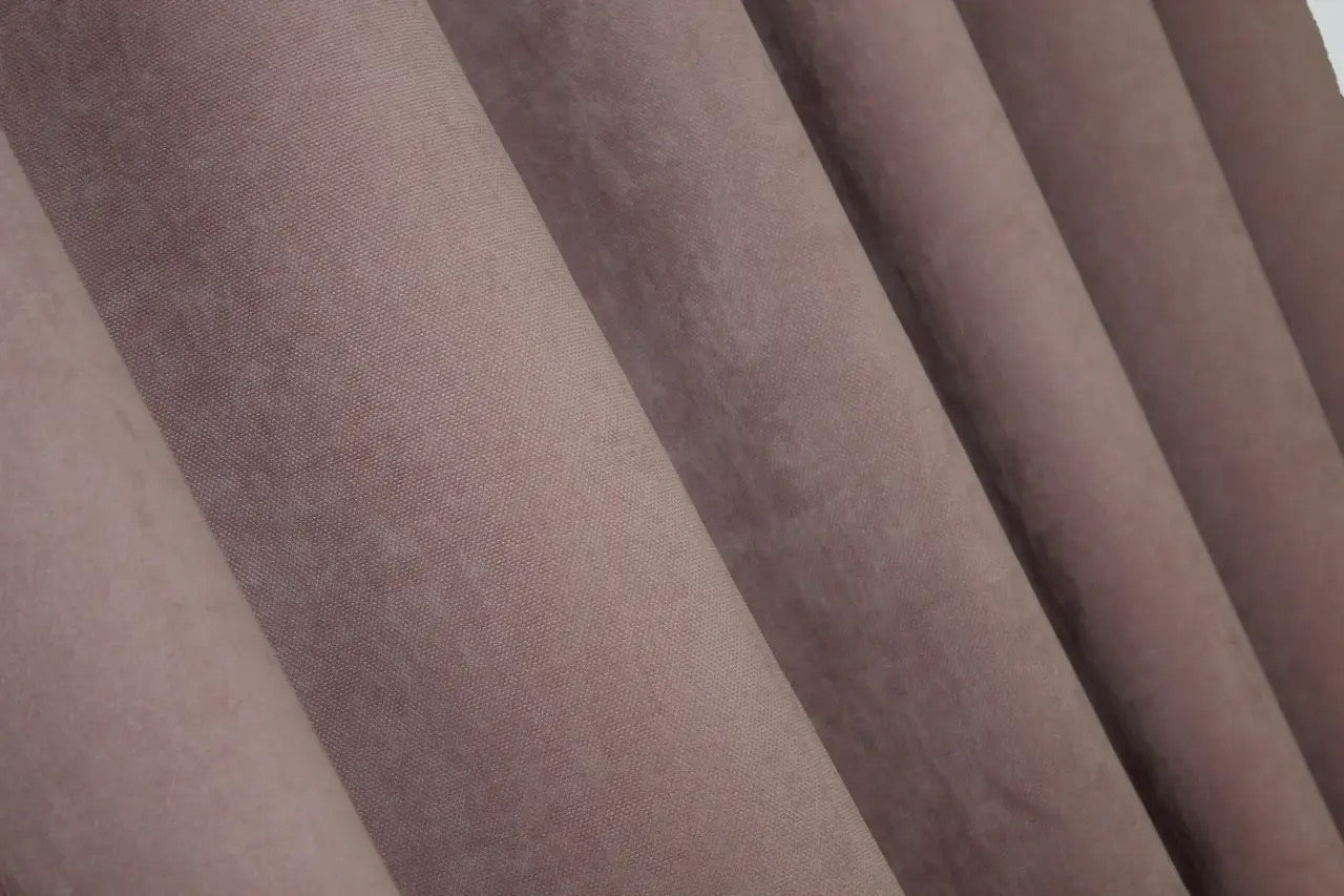 Blush pink velvet curtains with a flowing drape, ideal for contemporary and romantic home décor.
