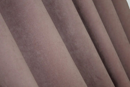 Blush pink velvet curtains with a flowing drape, ideal for contemporary and romantic home décor.
