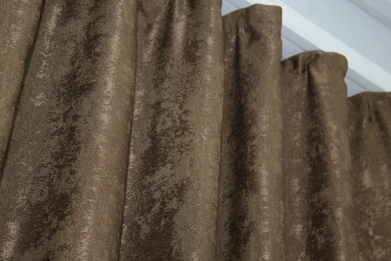 Rich brown jacquard curtains with a textured woven pattern, creating a luxurious yet warm and inviting atmosphere.
