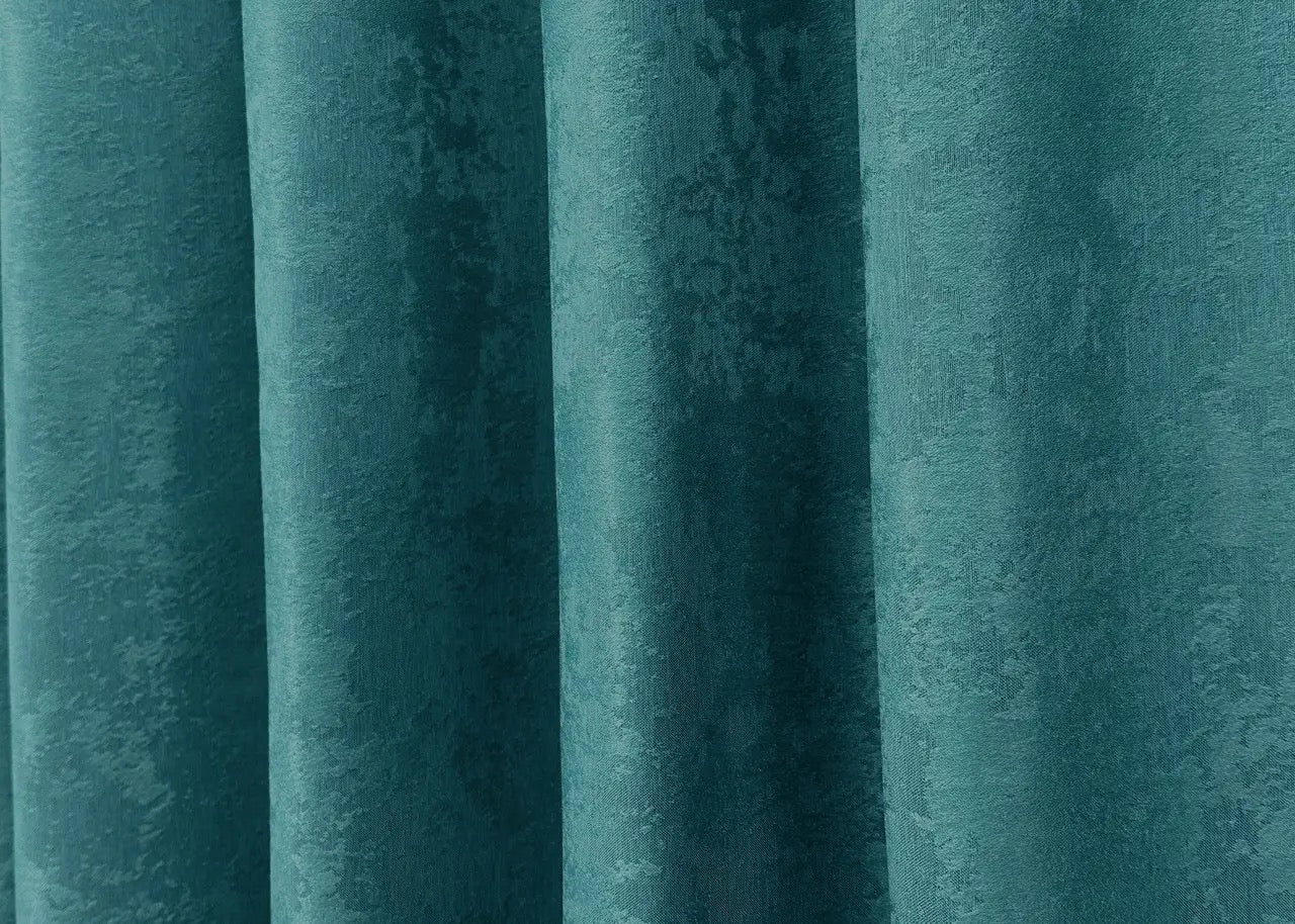 Rich peacock blue jacquard curtains with a woven pattern, creating a serene and inviting atmosphere in any room.
