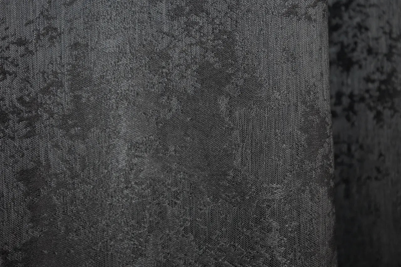 Modern graphite dark grey jacquard curtains with a textured woven pattern, creating a luxurious yet cozy and inviting atmosphere.
