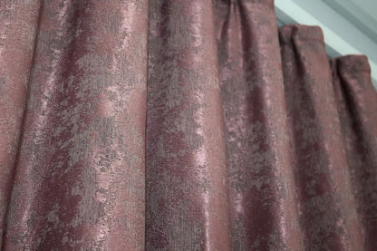 Rich raspberry grey jacquard curtains with a textured woven pattern, creating a luxurious yet warm and inviting atmosphere.
