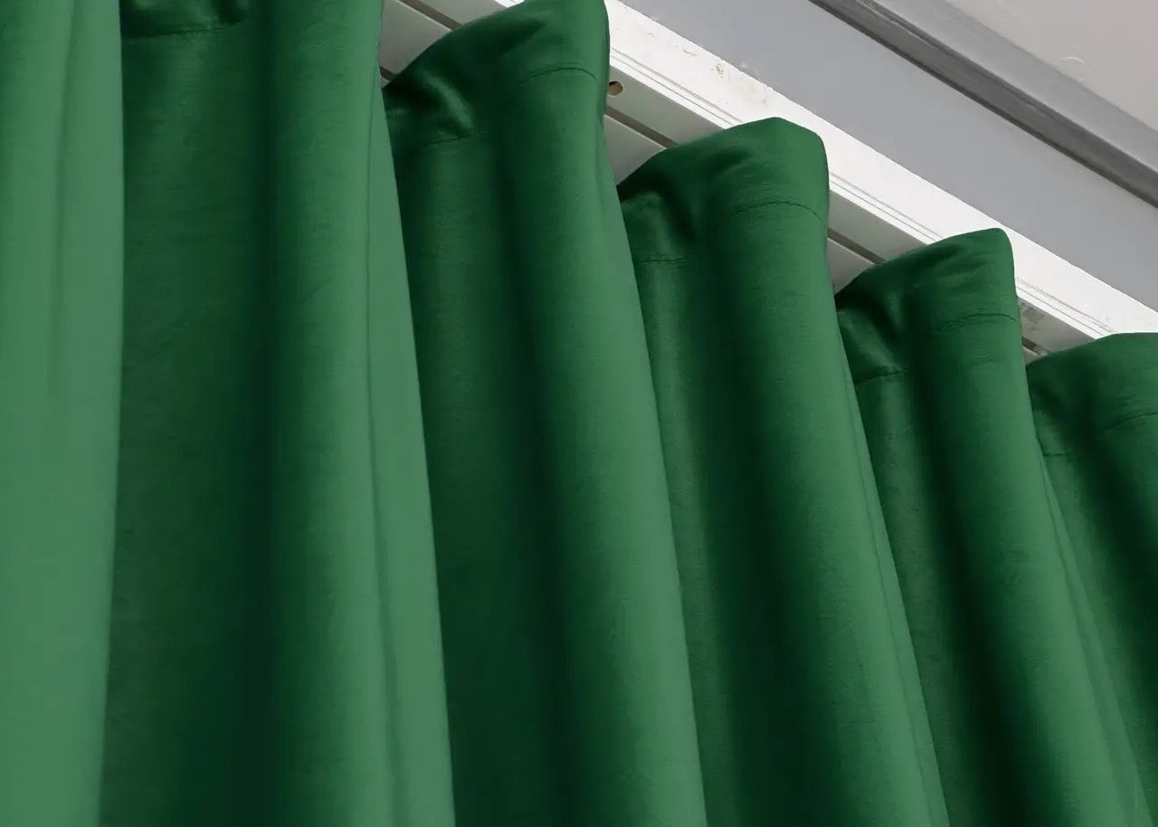 Pine green velvet blackout drapes, featuring thick, noise-reducing fabric for peaceful and stylish home spaces.
