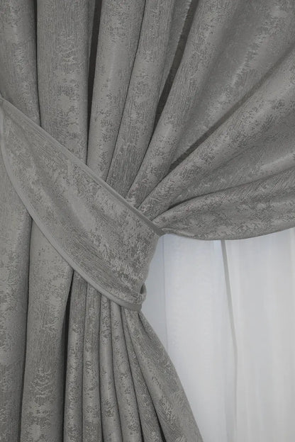 Set of two grey jacquard curtain panels with matching tie-backs, providing a polished and elegant window treatment.
