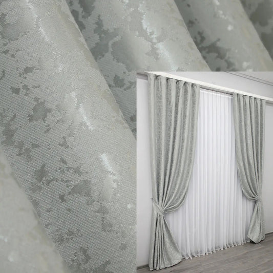 Elegant light grey linen curtains with a subtle marble pattern, adding modern sophistication to any interior.
