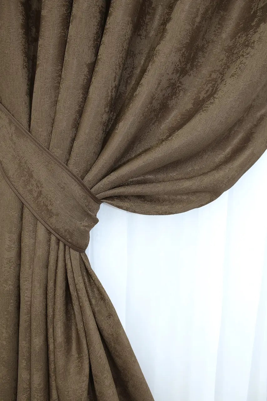 Non-blackout brown jacquard curtains that provide privacy while letting soft natural light filter through.
