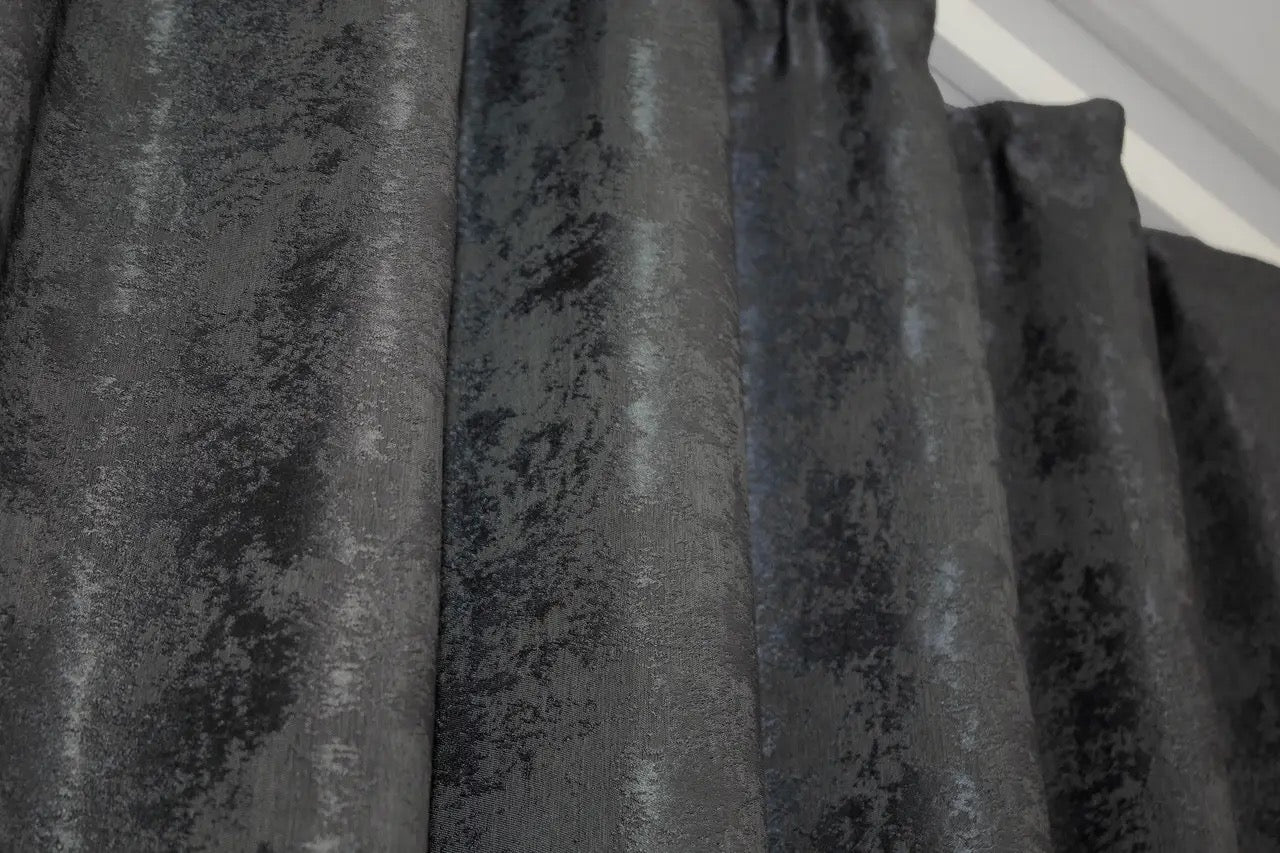 Non-blackout graphite dark grey jacquard curtains that provide privacy while letting soft natural light filter through.
