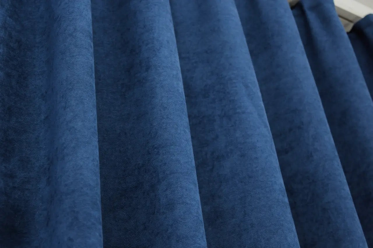 Rich blue curtains with a smooth, flowing drape, perfect for creating a cosy and stylish atmosphere.
