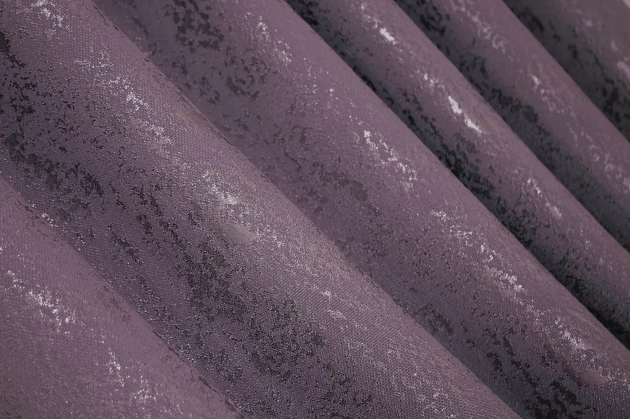 Soft-textured purple linen drapes with a marble effect, creating an inviting and refined atmosphere.
