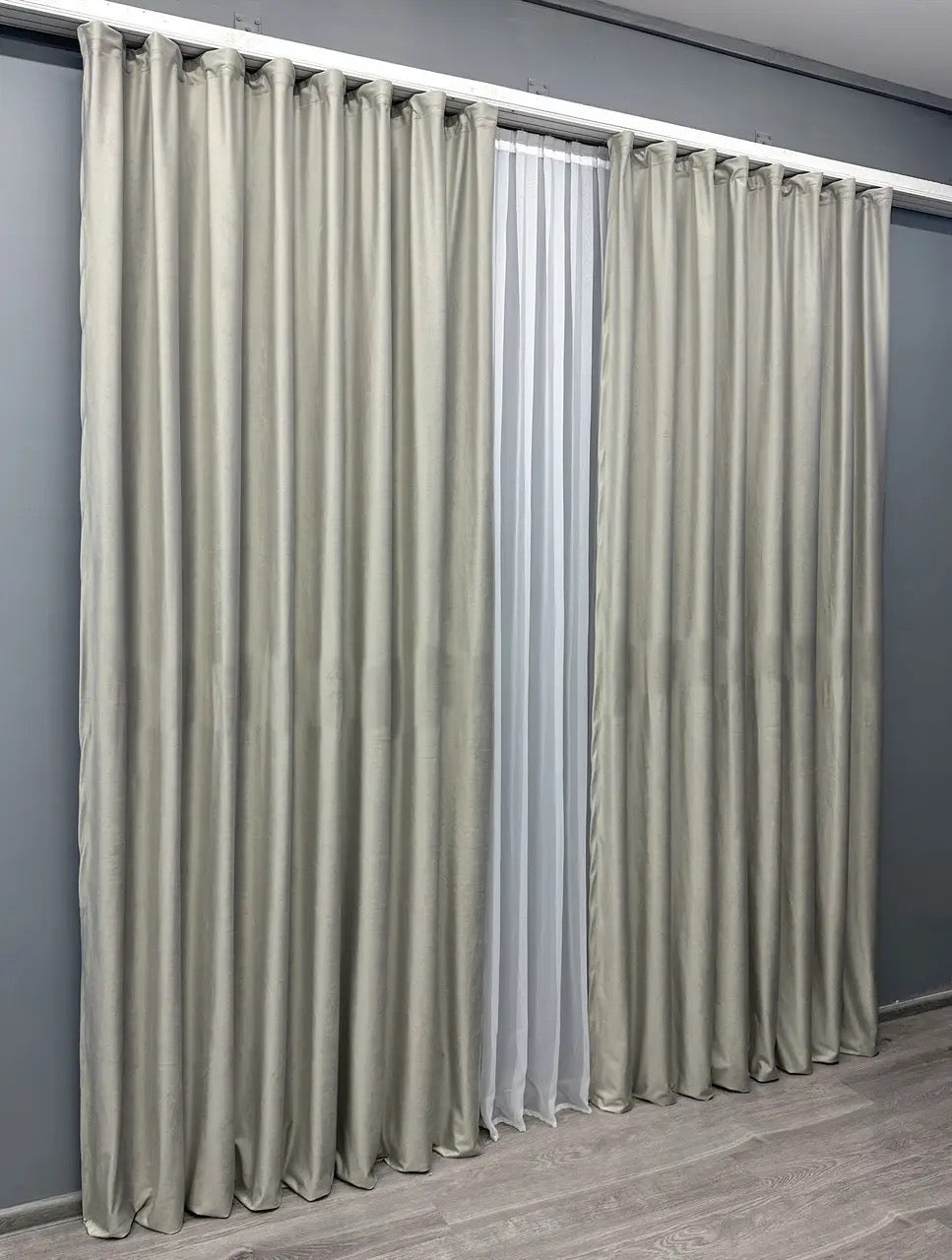 Oyster grey velvet blackout curtains with a smooth, flowing drape, crafted for sophisticated bedrooms, living rooms, and formal settings.
