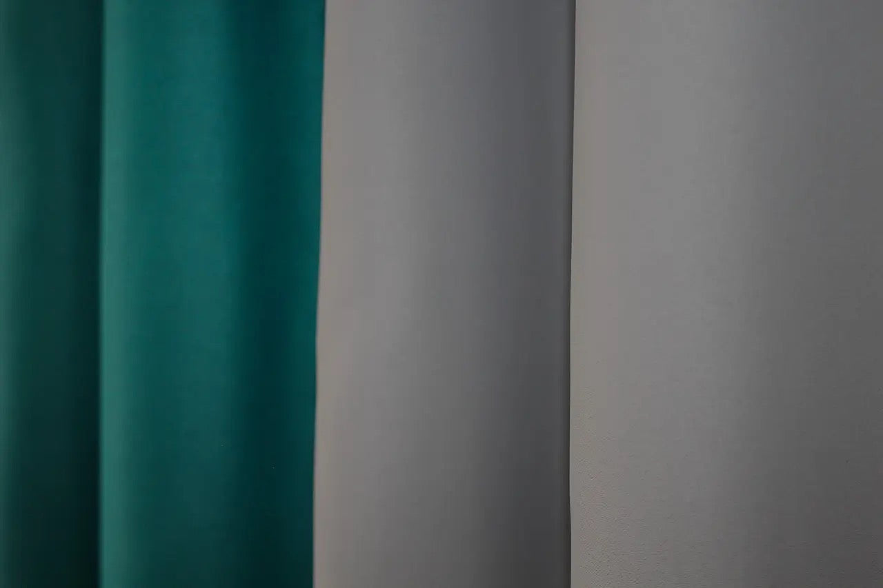 Stylish combined blackout curtains in emerald and grey, adding depth and elegance to contemporary décor.
