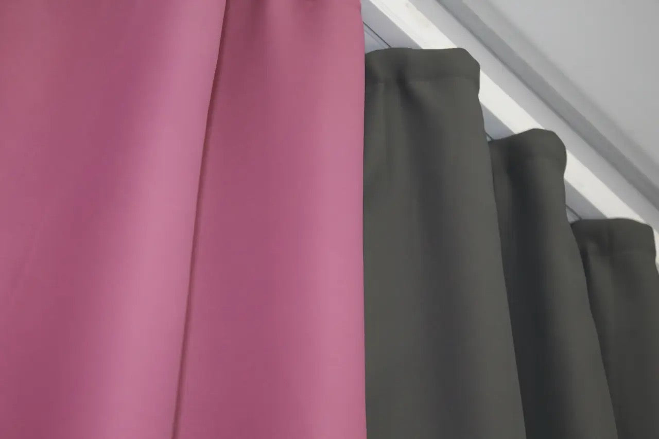 Stylish combined blackout curtains in graphite (charcoal) and fuchsia (raspberry), adding depth and elegance to contemporary décor.
