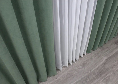 Muted green velvet curtains with a plush texture, enhancing any contemporary or classic space.
