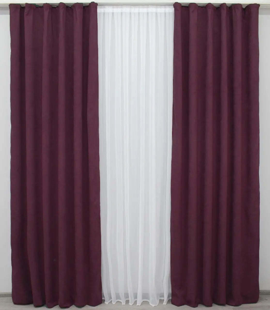 Plush burgundy velvet drapes with a sophisticated sheen, offering warmth and elegance.
