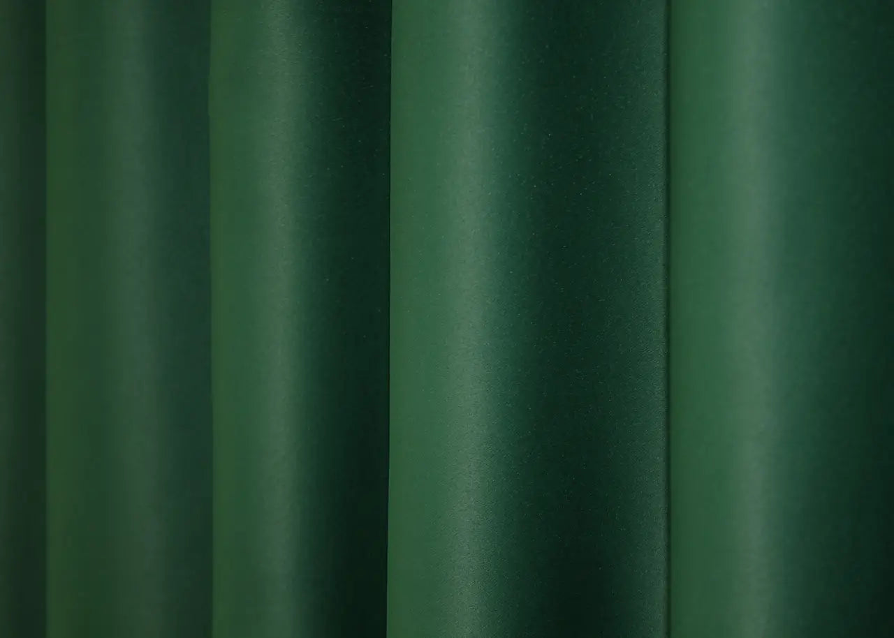 Rich green blackout curtains offering warmth and superior light control.
