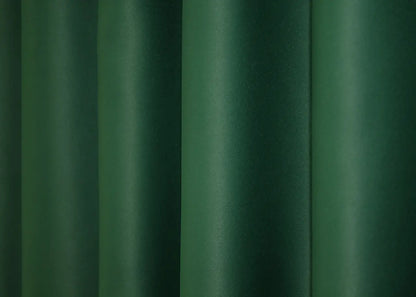 Rich green blackout curtains offering warmth and superior light control.
