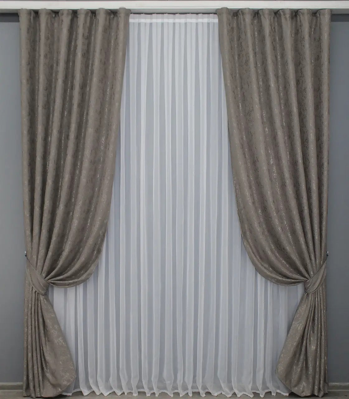 Soft brown-grey linen drapes with a delicate textured fabric, perfect for cosy and stylish interiors.
