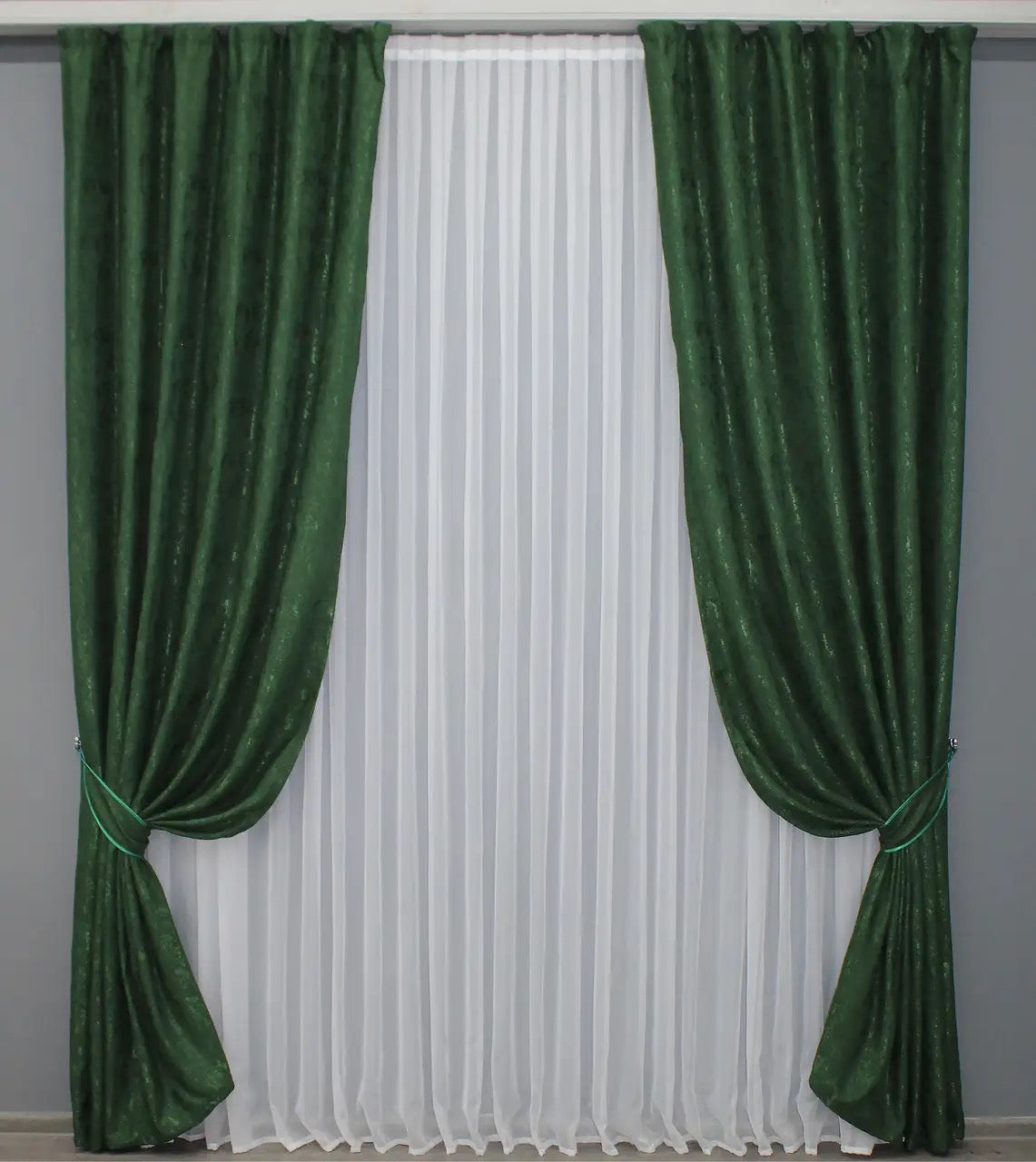 Soft emerald green linen drapes with a delicate textured fabric, perfect for cosy and stylish interiors.
