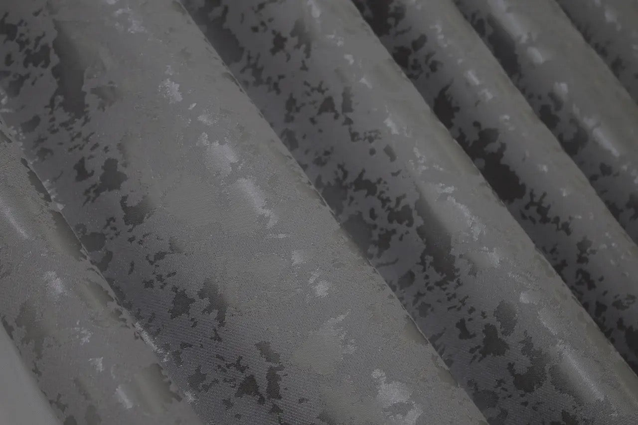 Soft grey linen drapes with a delicate marble texture, perfect for stylish and contemporary home decor.
