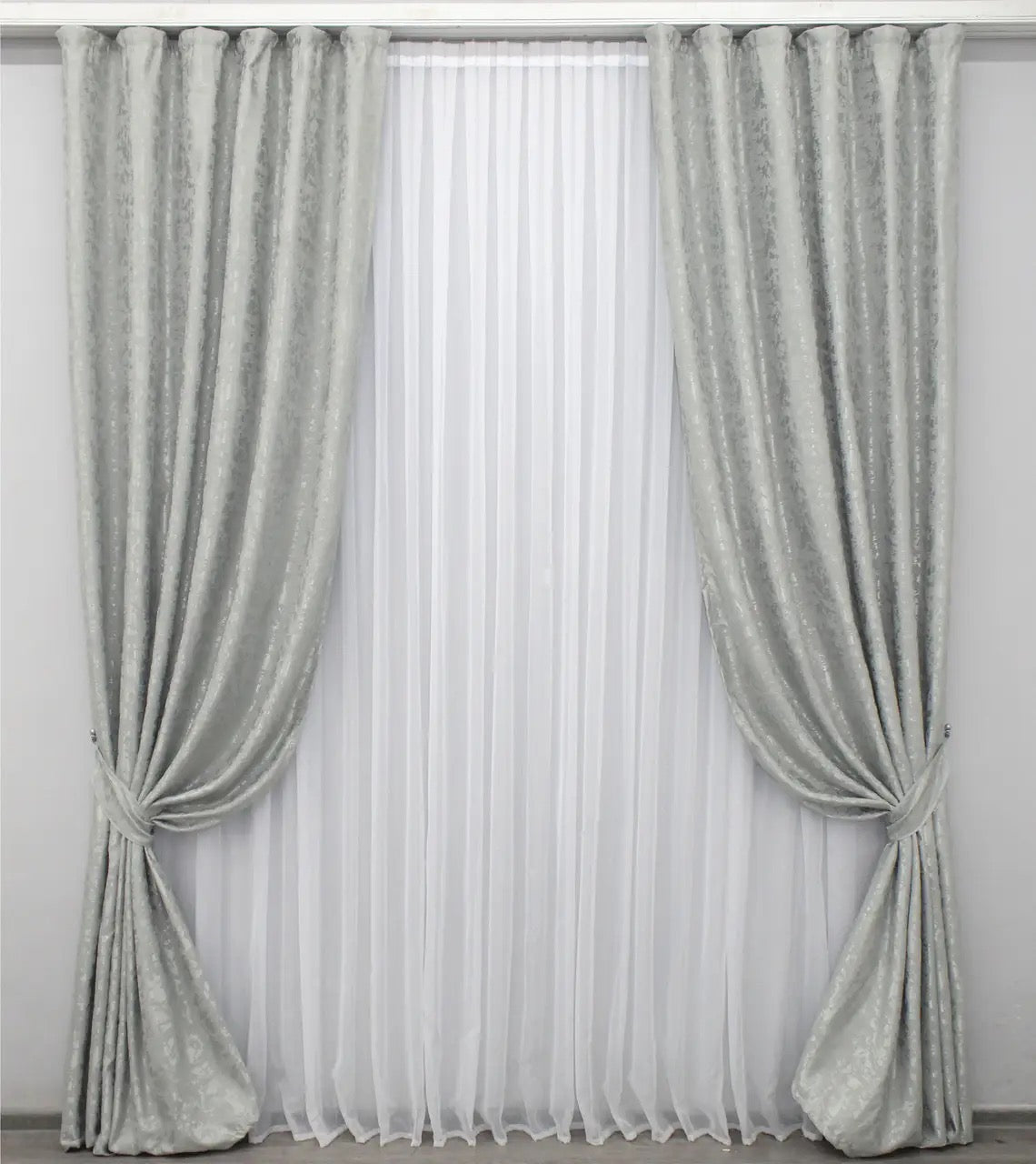 Soft light grey linen drapes with a delicate marble texture, perfect for stylish and contemporary home decor.
