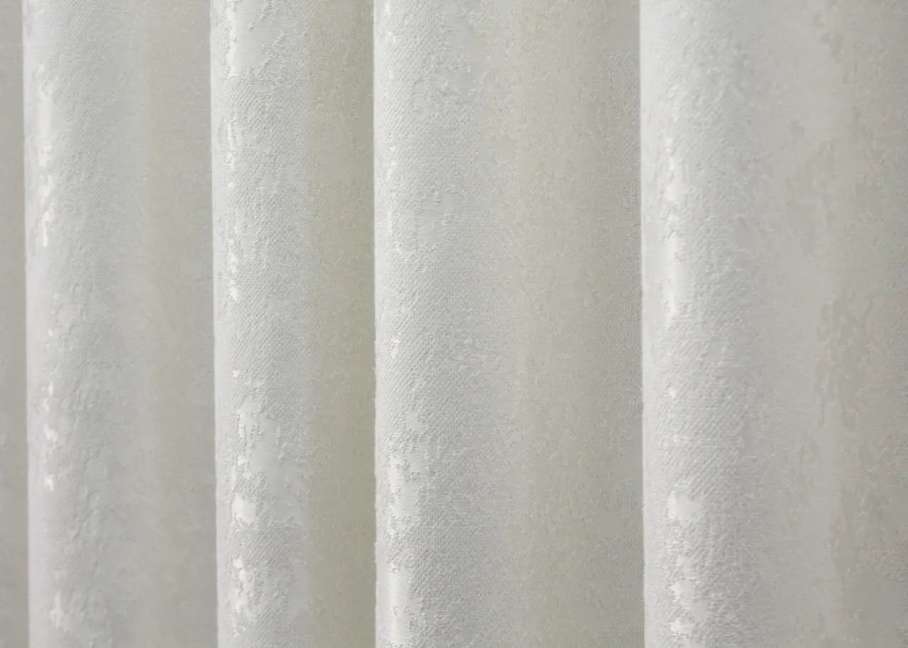 Timeless cream linen drapes with a subtle marble pattern, perfect for bright, minimalist interiors.
