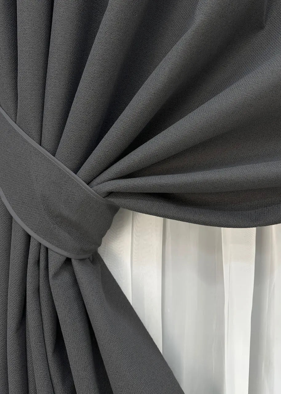 Minimalist graphite blackout drapes with universal tape loops, suitable for various curtain rods and hooks.
