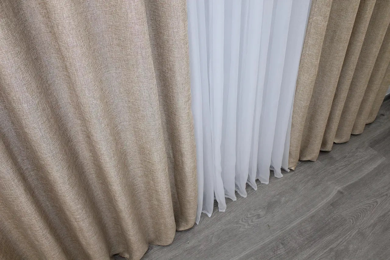 Taupe linen curtains with a coarse weave, bringing warmth and sophistication to any rustic space.
