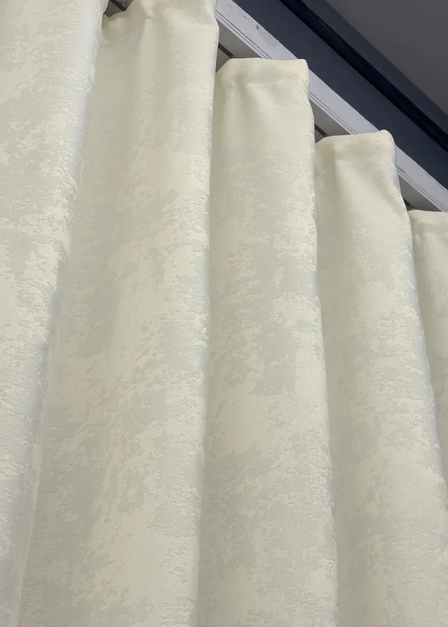 Textured cream jacquard curtains, featuring a timeless pattern that complements both modern and traditional interiors.
