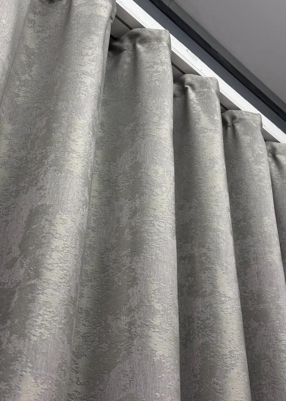 Textured light grey jacquard curtains, featuring a timeless design that complements both modern and traditional interiors.
