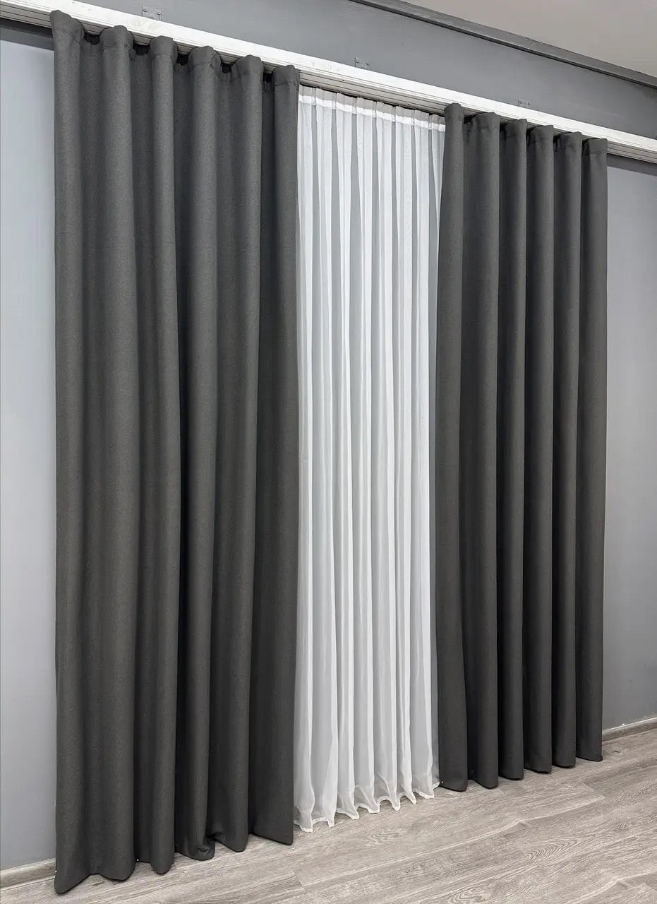 Thick graphite blackout curtains with a smooth matte finish, providing complete privacy and contemporary style.
