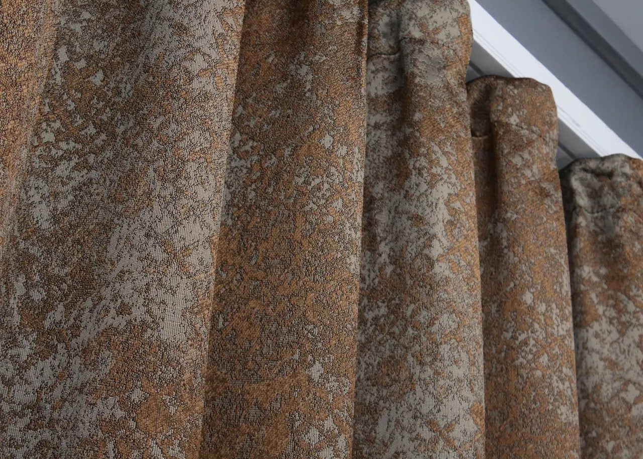 Luxury light-filtering linen curtains in warm copper and grey, offering privacy with a natural diffused glow.
